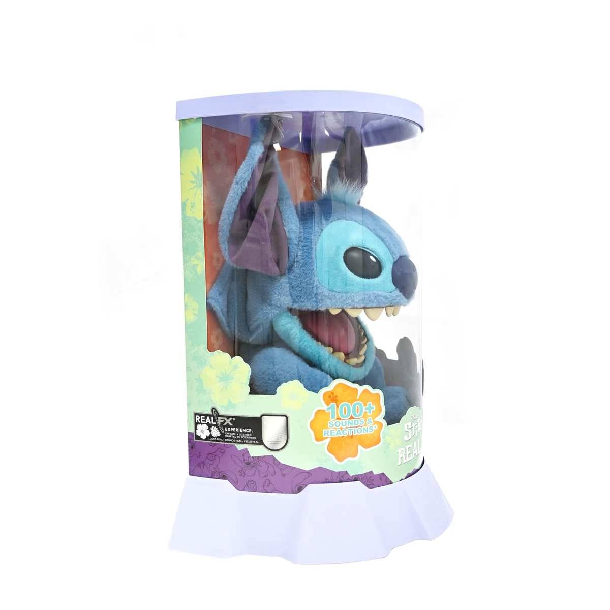 Blaues plüschiges Stitch-Spielzeug in einer durchsichtigen Schachtel, mit der Aufschrift "100+ Sounds und Reaktionen"" und ""Real FX"".