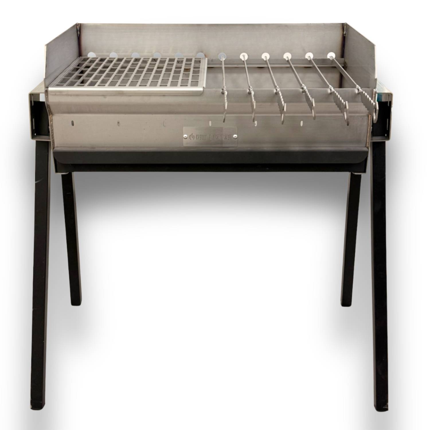 Edelstahl-Holzkohlegrill mit seitlicher Feuerbox, Grillrost und vier Spießen auf schwarzen Beinen vor weißem Hintergrund.