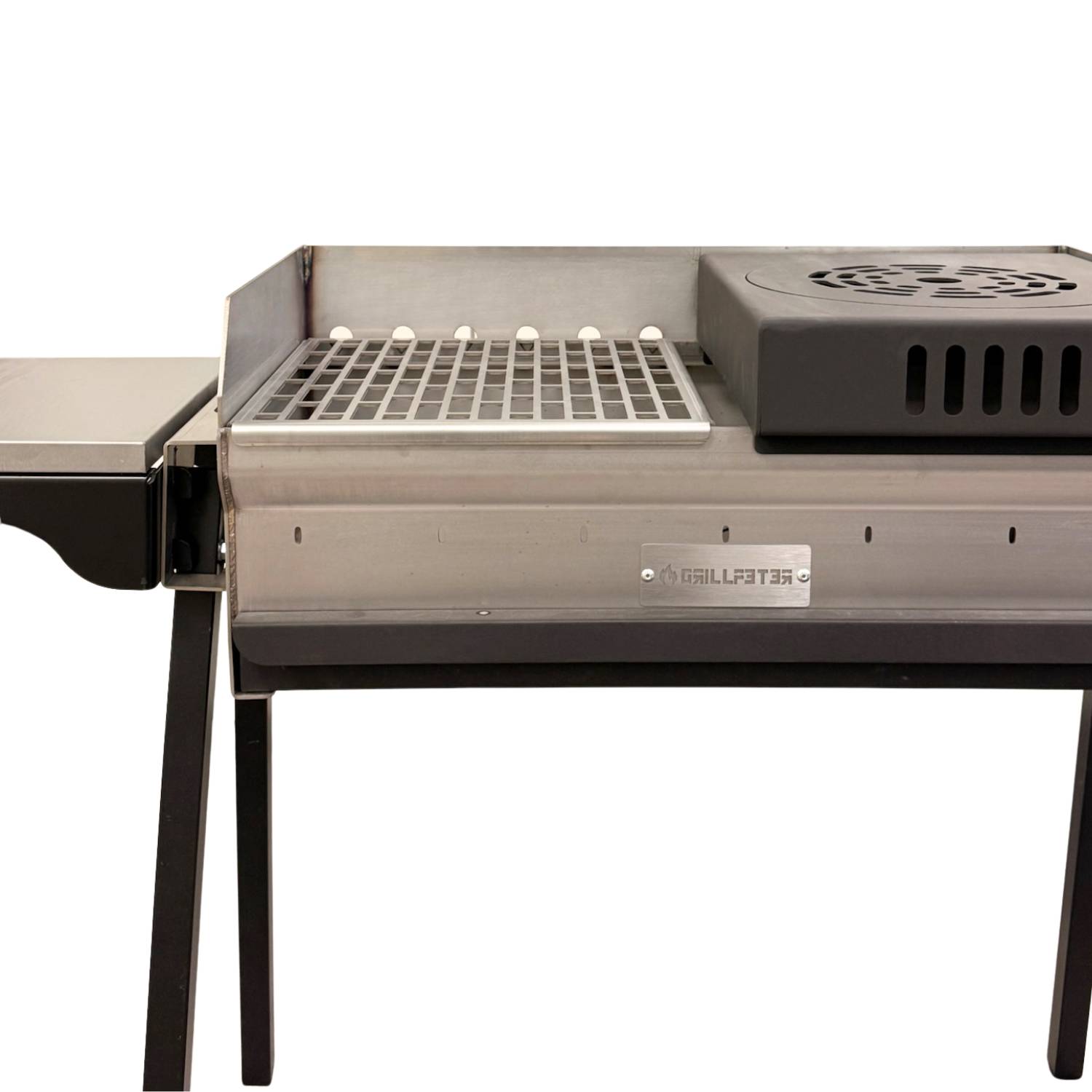 Edelstahl-Außengrill mit Seitenfach, Rost und belüftetem Wärmebox auf schwarzen Beinen vor weißem Hintergrund.