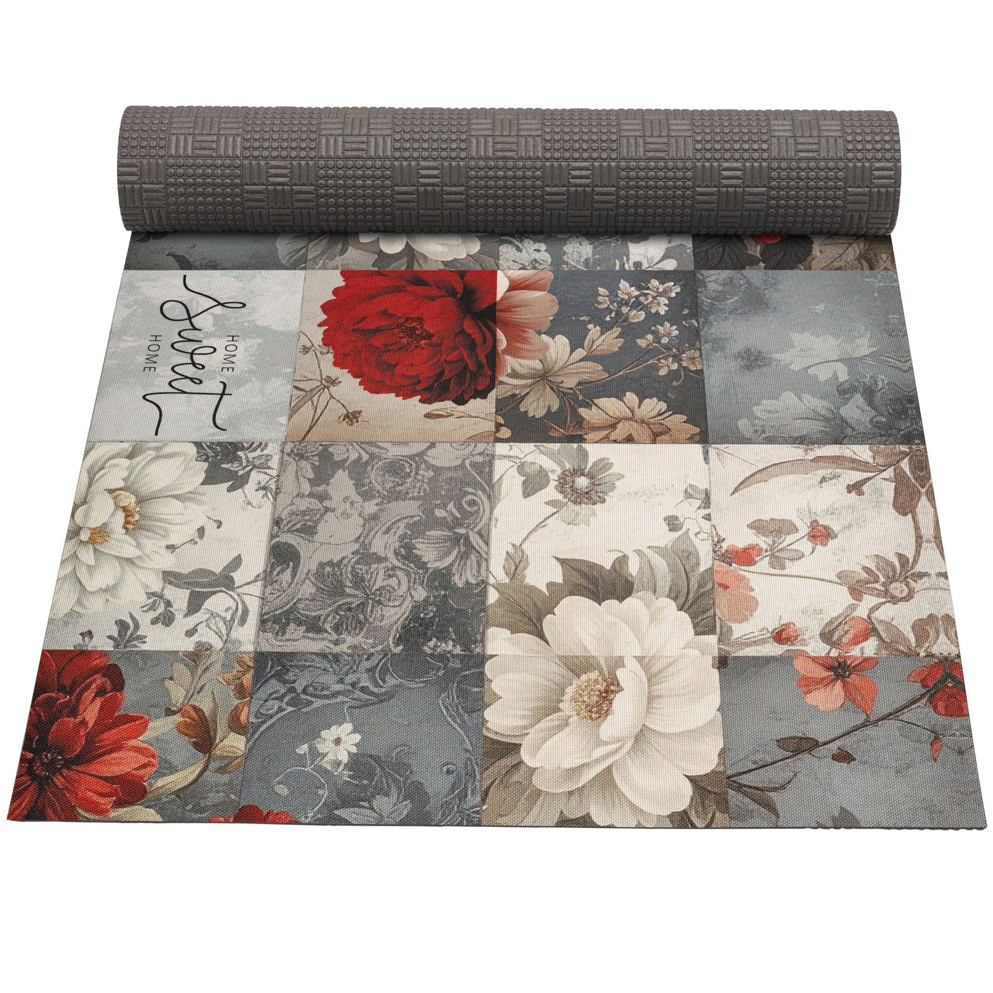 Aufgerollter grauer strukturierter Teppich mit Patchwork-Blumendruck in gedämpften Grau-, Creme- und Rottönen.