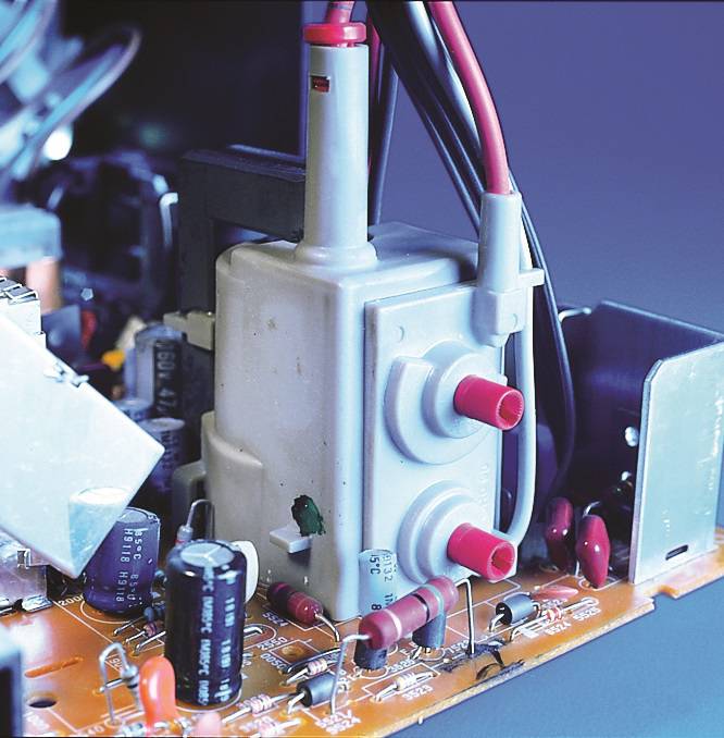 Electronic circuit board with various electronic components, including capacitors, resistors, and cables connected to a central terminal block.