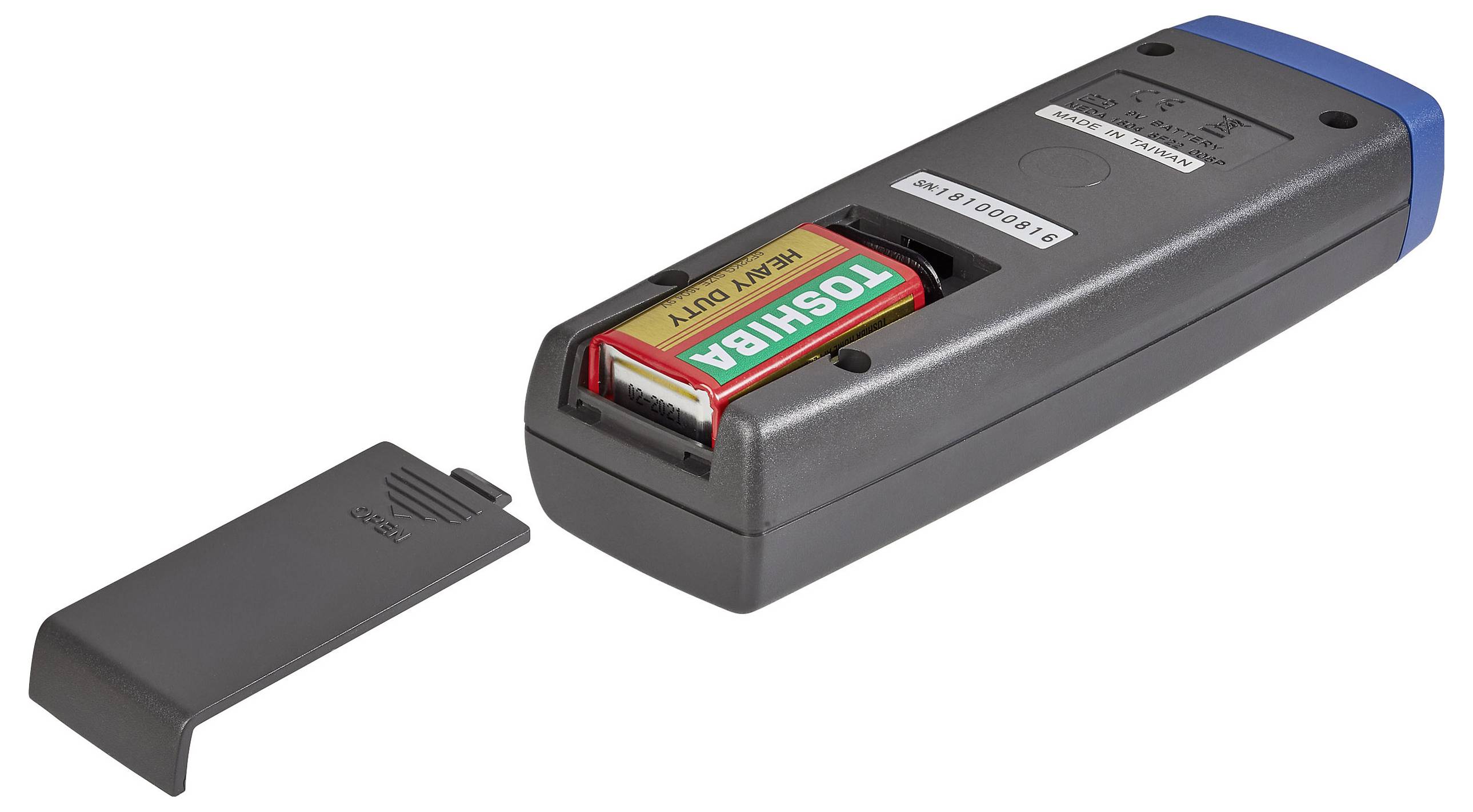 A battery compartment is open on a gray electronic device with a 9V battery inside. The compartment cover is removed, showing the battery.