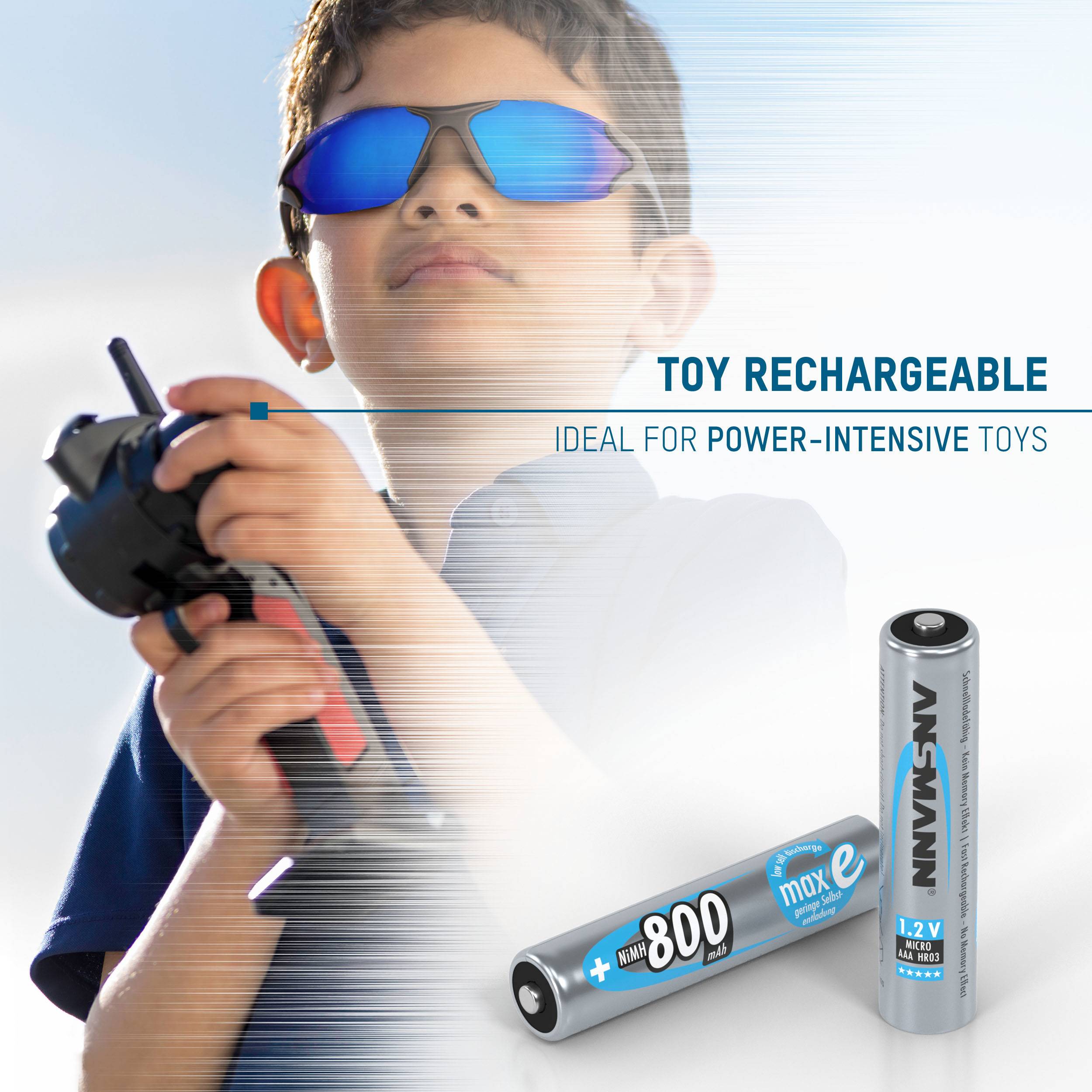 A child wearing sunglasses is playing with a toy remote control. Alongside are rechargeable batteries for high-energy toys.