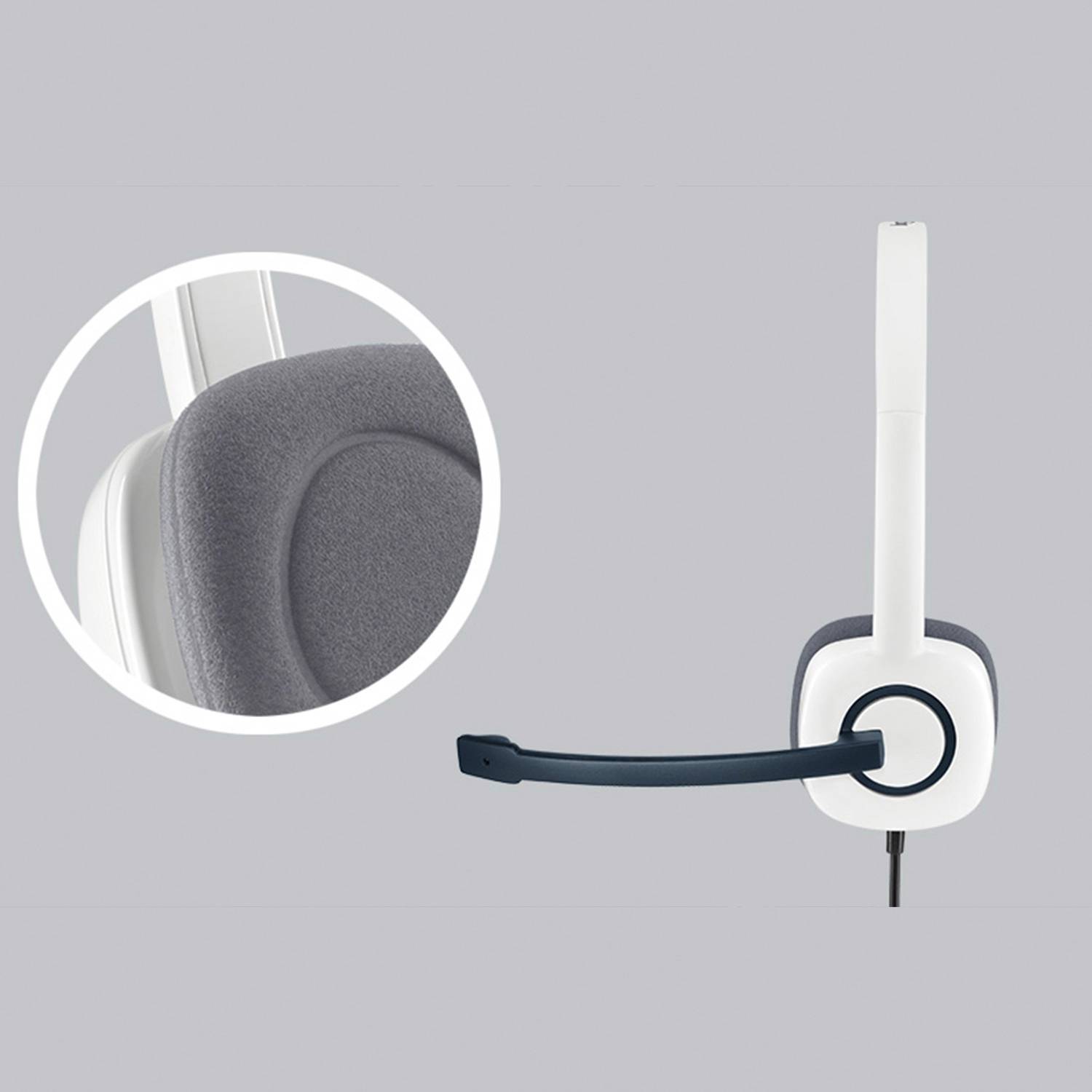 Headset with grey ear cushion and blue microphone arm on a grey background. Close-up reveals the soft padding material.