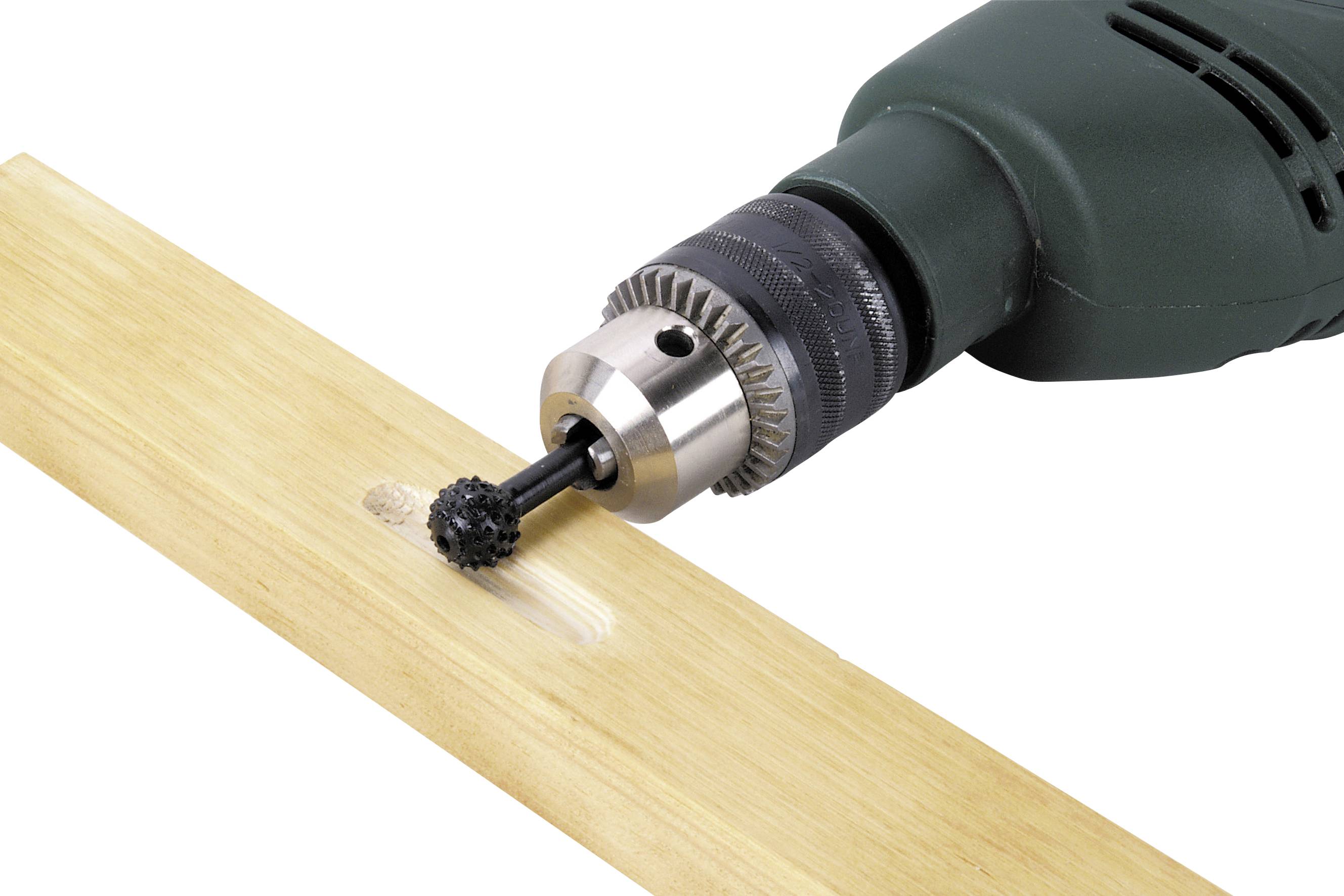 A green drill with a brush head is sanding a spot on a wooden board.