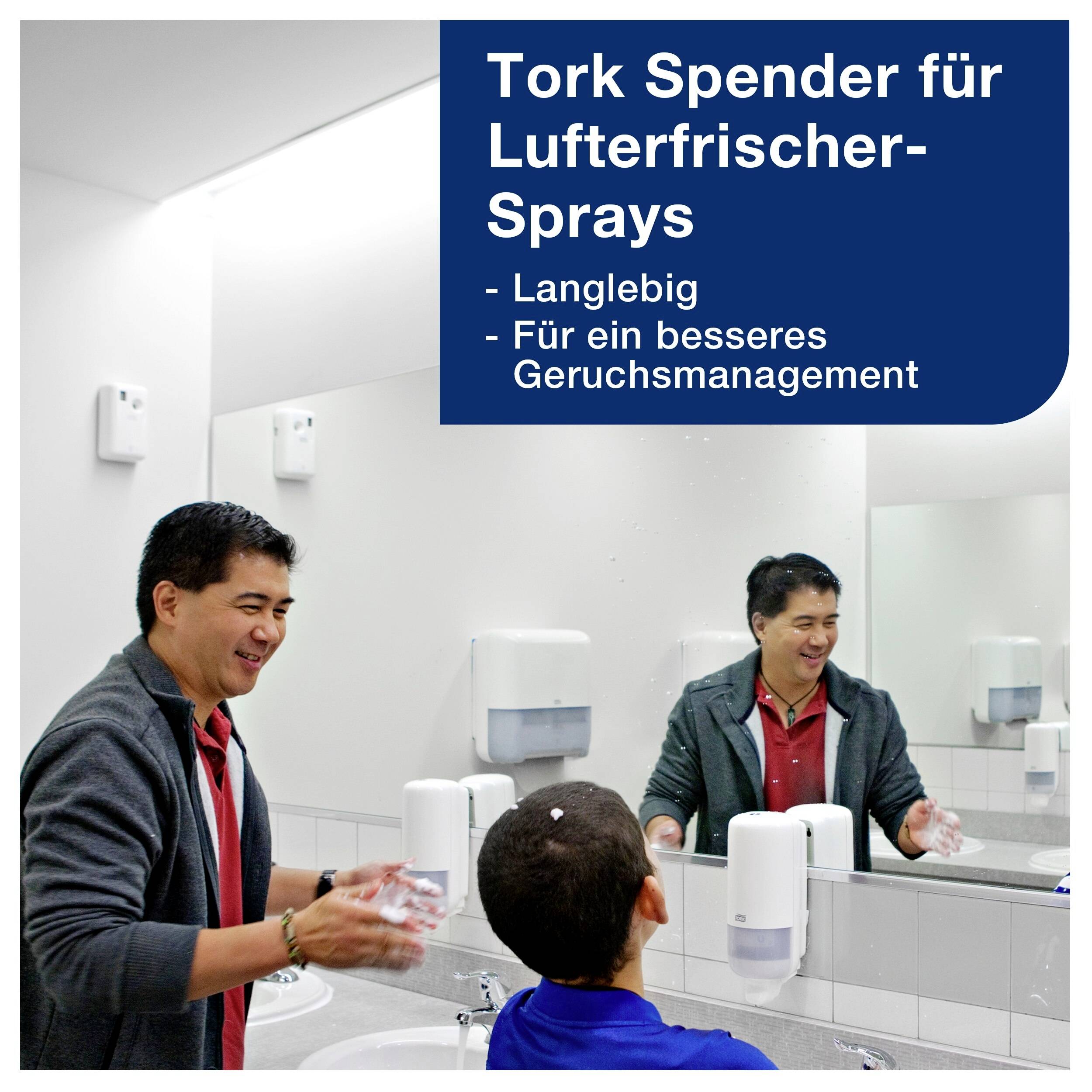 Man in washroom using hand dryer while a child watches. Text: 'Tork dispenser for air freshener sprays. Long-lasting, For better odour management.'