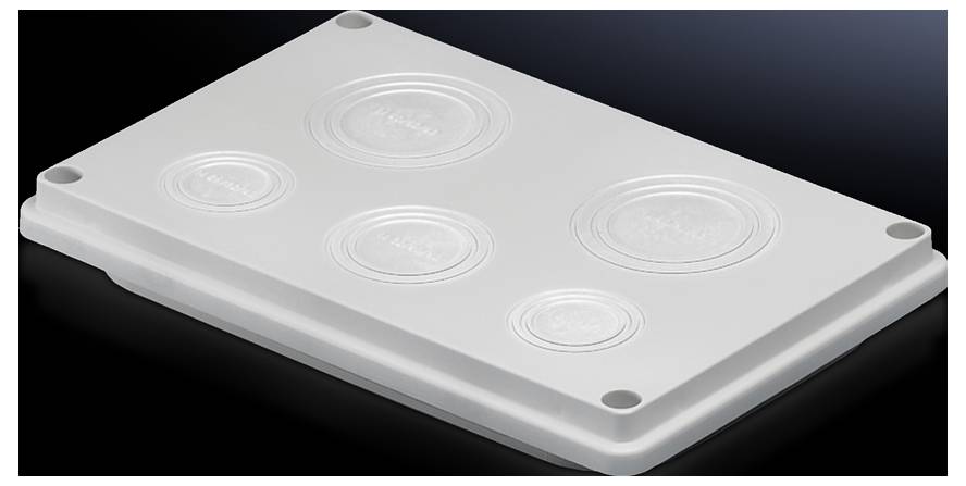 A white lid with four round protrusions rests on a dark surface.