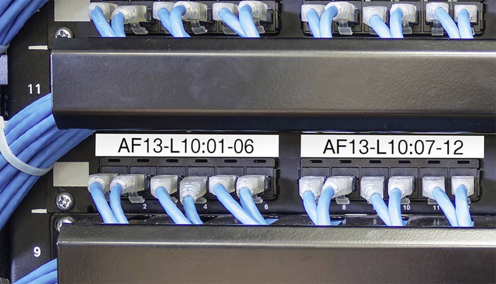 Network distributor connected with blue Ethernet cables. Two labels show the numbering 'AF13-L10:01-06' and 'AF13-L10:07-12'.
