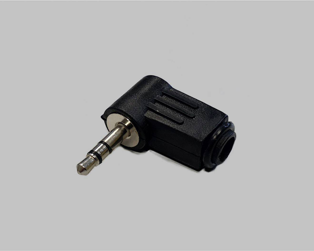 A black 3.5-mm audio adapter, rectangular in shape, on a grey background. Purpose: connecting audio cables with different connections.