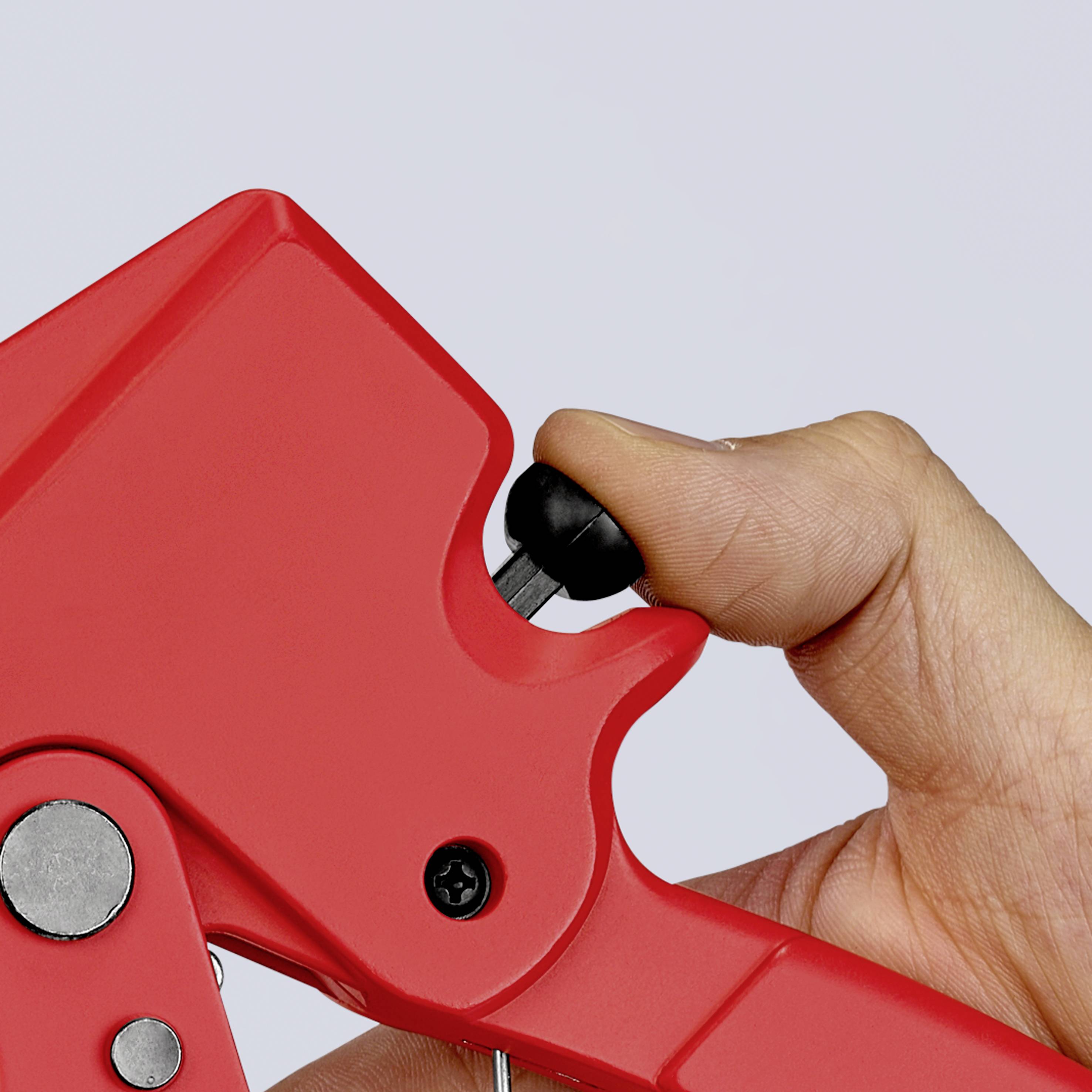 A hand operates a red lever of a mechanical device.