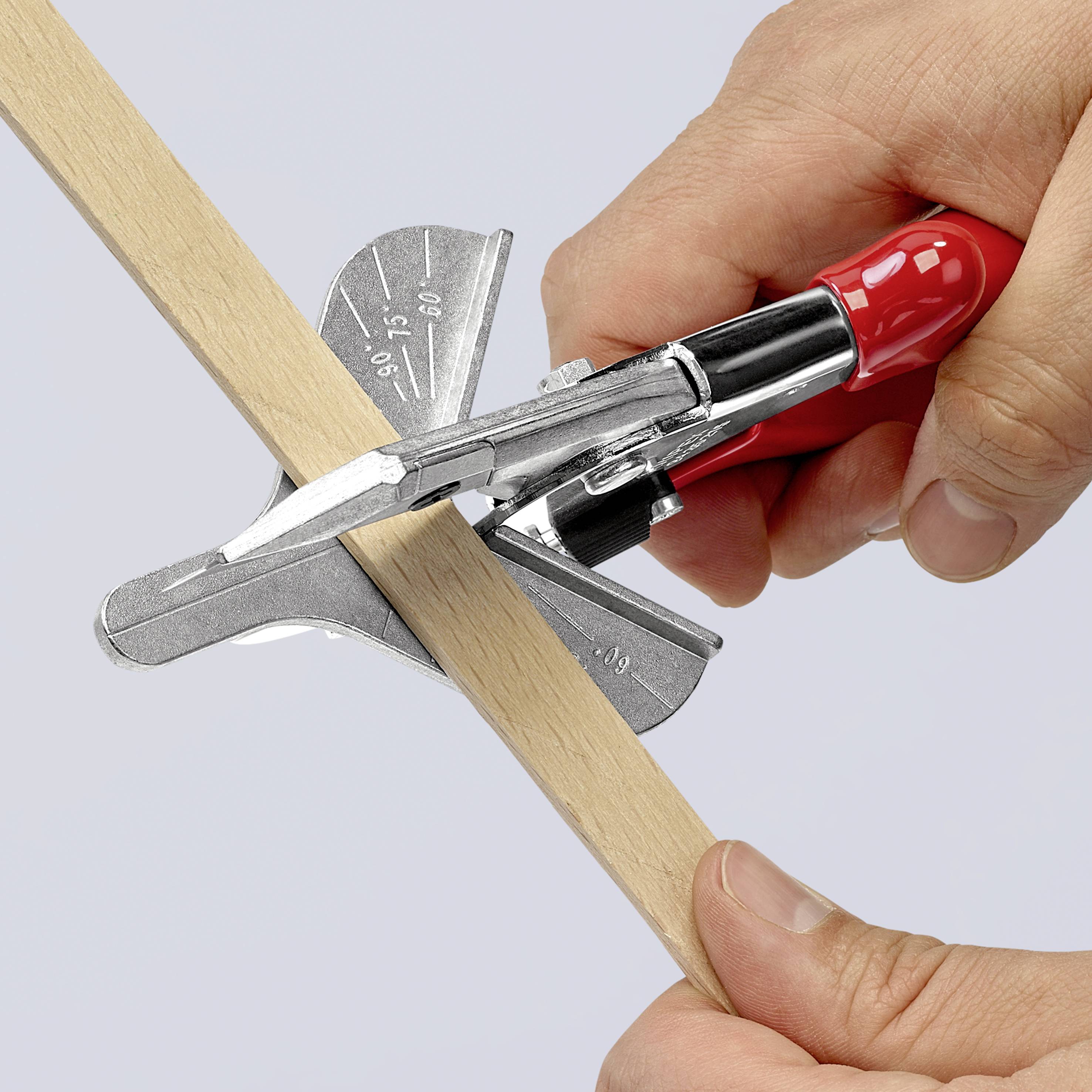 A person is cutting a piece of wood at a precise angle using a red mitre shears.