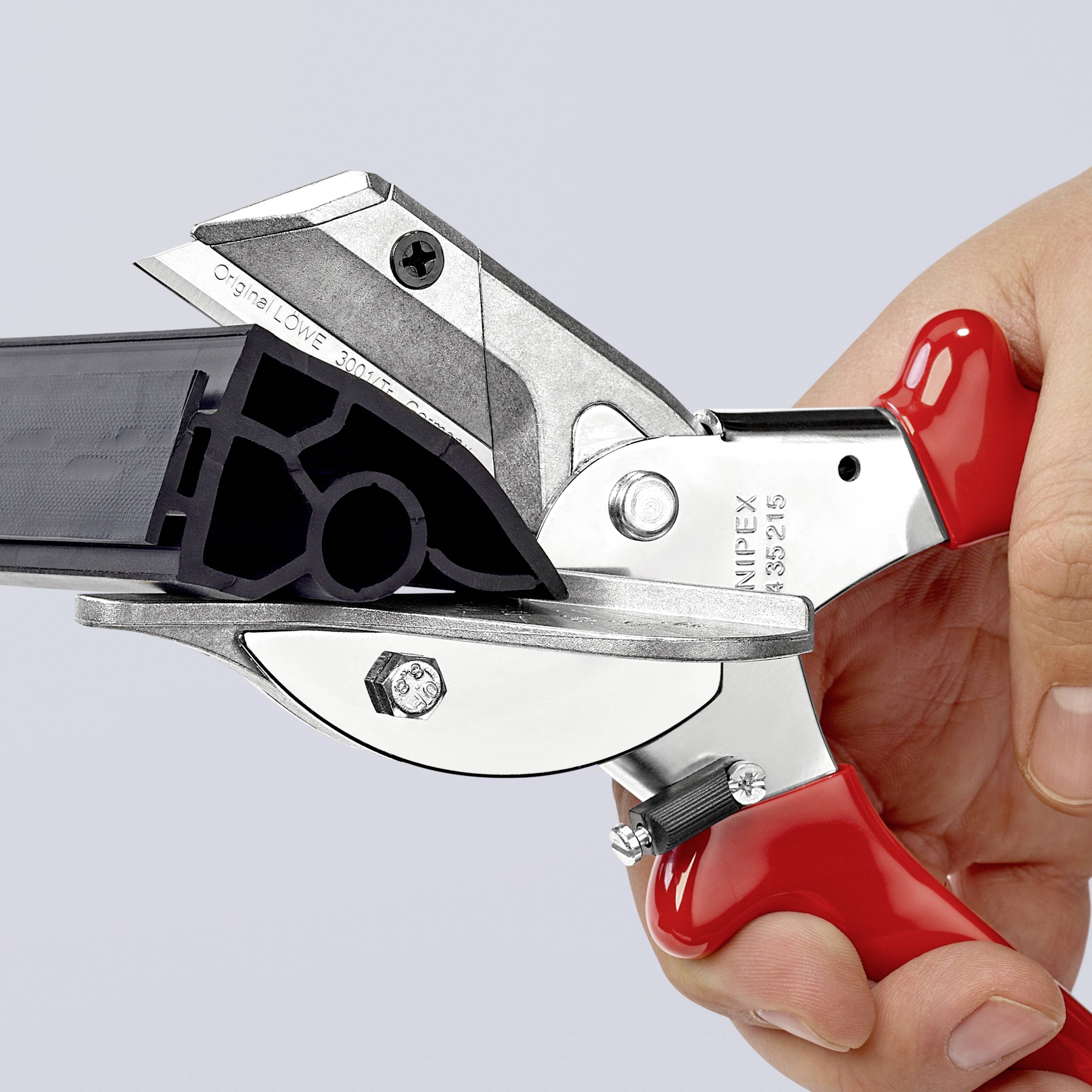 A person is holding a brightly red scissors with a special cutting blade design, suitable for cutting profile materials.