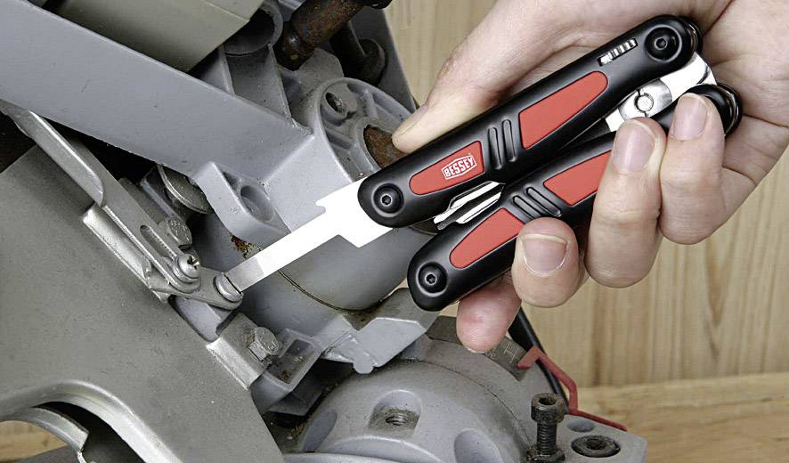 A multi-tool is used to loosen a screw on a machine.