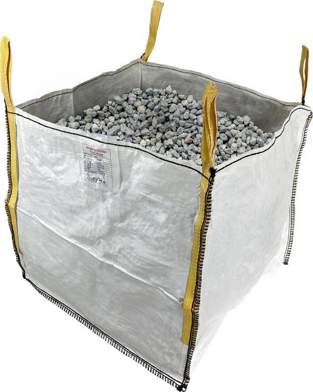 Large white bulk bag, filled with small grey stones. Four yellow carry handles at the corners for easy transportation.