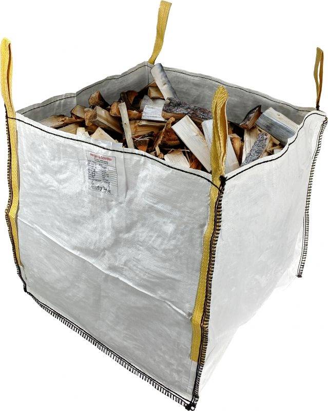 Large white sack filled with logs. Four yellow loops at the top for carrying. The sack is standing upright.