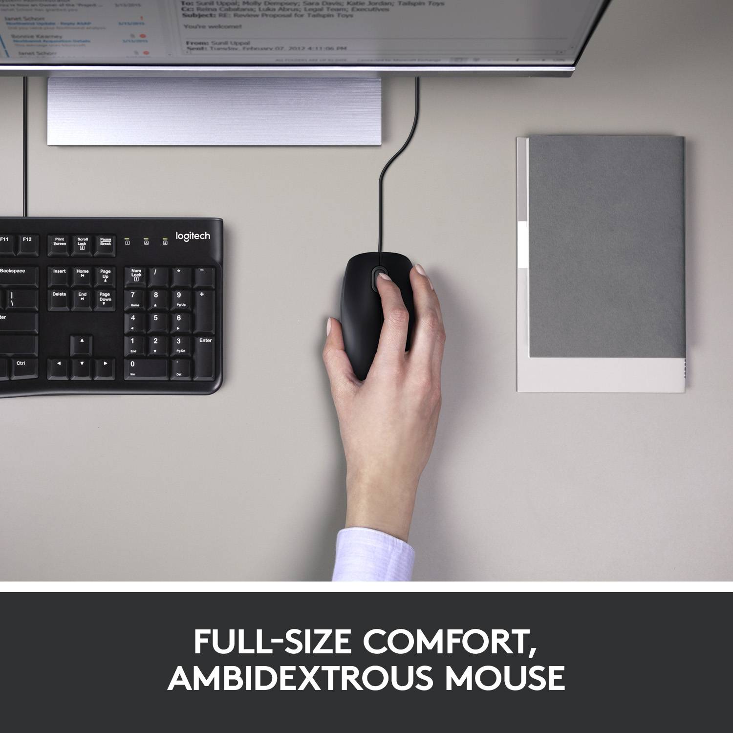 A hand uses a mouse on a desk next to a keyboard. Screen displays a menu. Below the text reads: 'User-friendliness in standard size'.