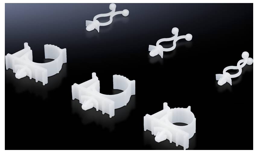 A group of white plastic clips in various shapes and sizes against a black background.