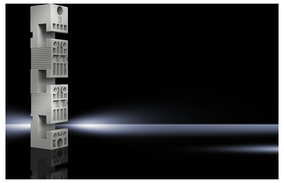 A white, rectangular plastic block with various openings and grooves stands vertically against a dark, slightly illuminated background.