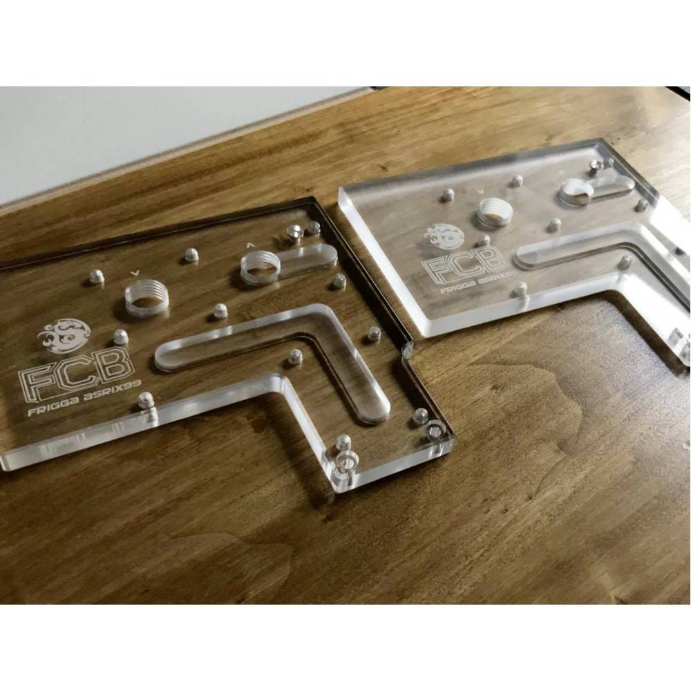 Clear acrylic corners with FCB logo, placed on a wooden surface. Each piece has holes and grooves, possibly for mounting or assembly.