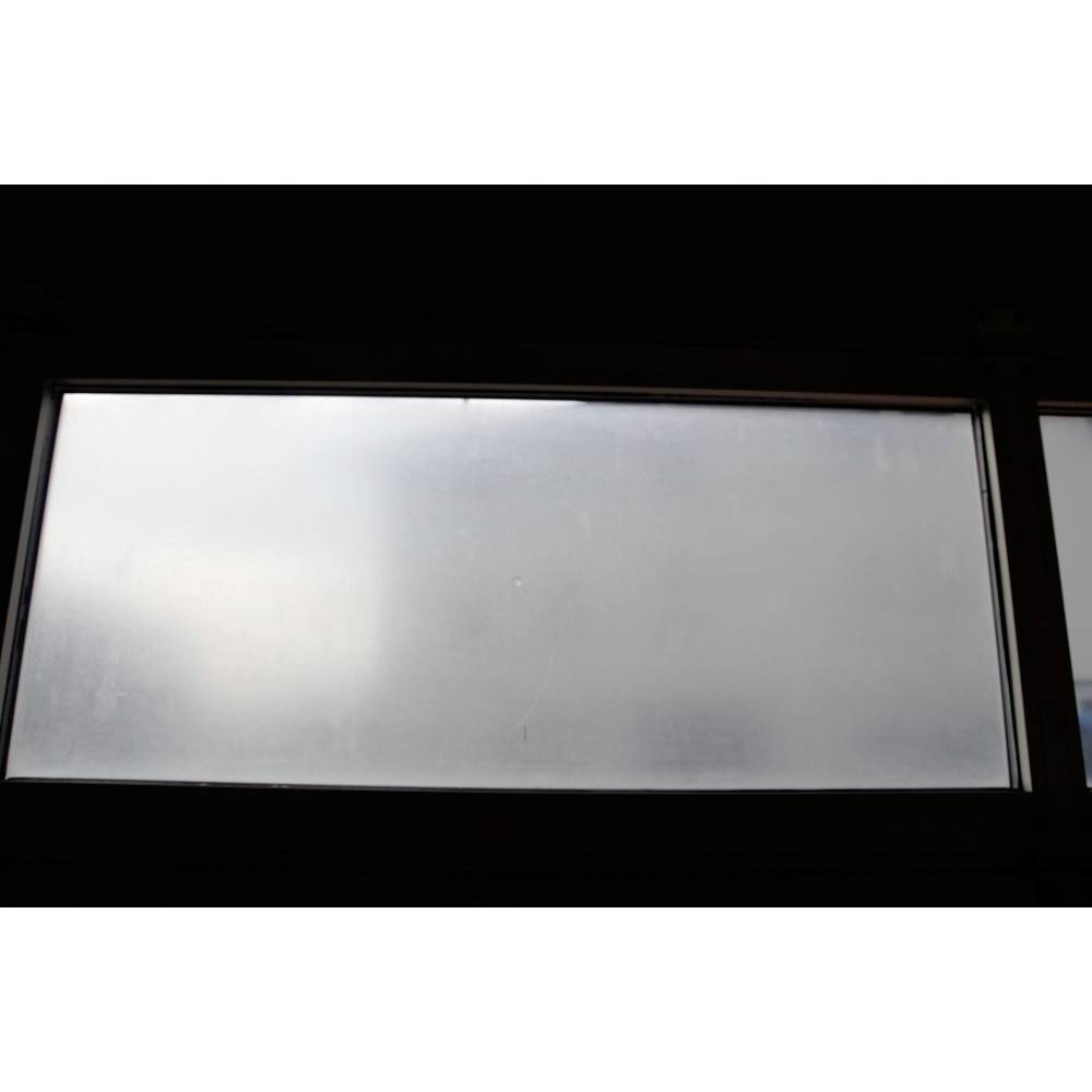 A window with frosted glass, allowing light to filter through but obscuring any clear view outside.