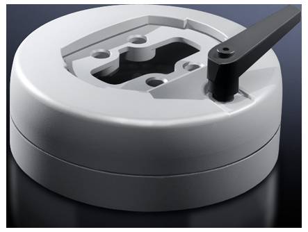 A round, grey metallic object with a lever on its side, lying on a dark surface.