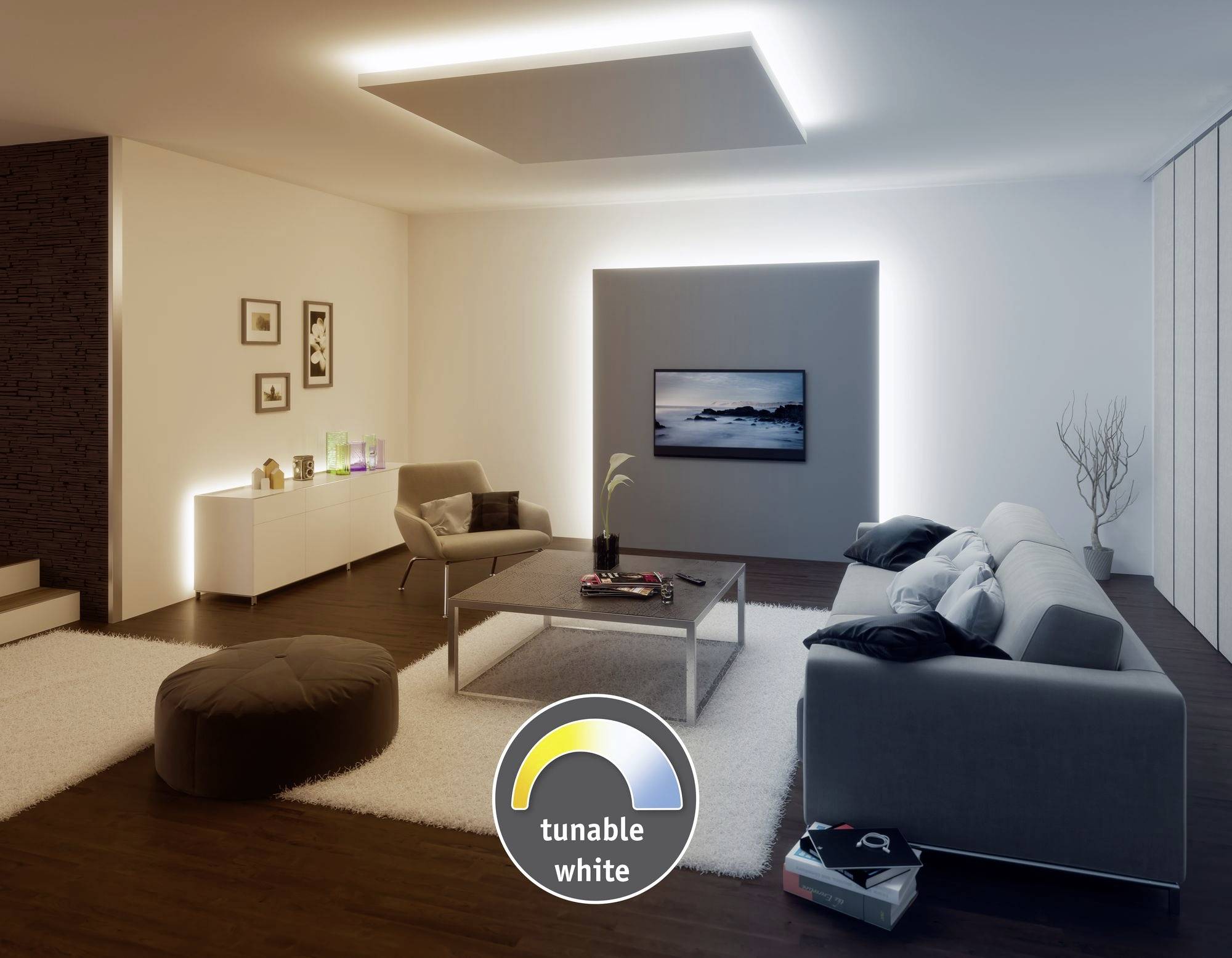 Elegant living room with a modern sofa and armchair. The television is mounted on the wall, illuminated by soft LED lighting.