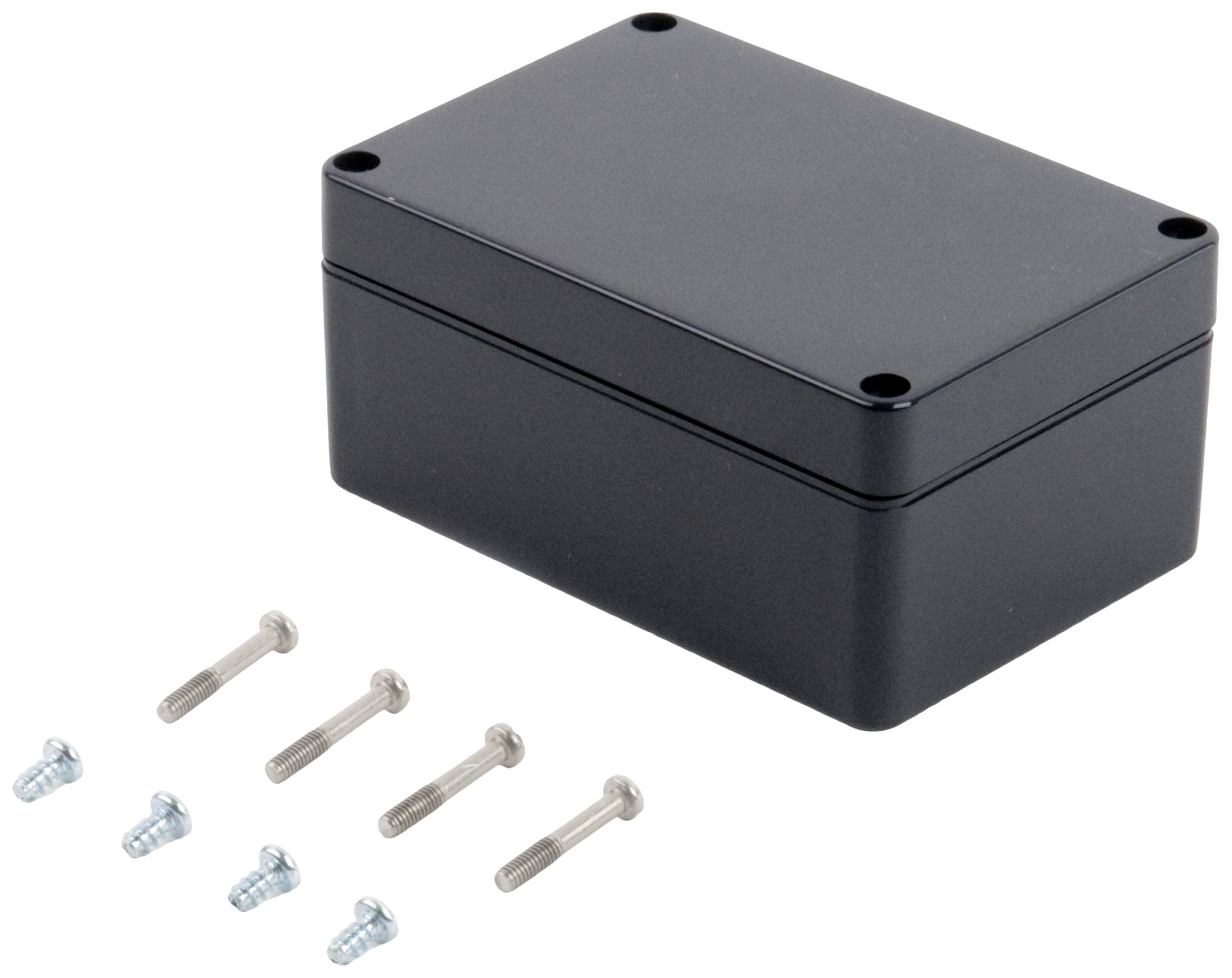 A black, rectangular enclosure with rounded corners lies next to six screws.