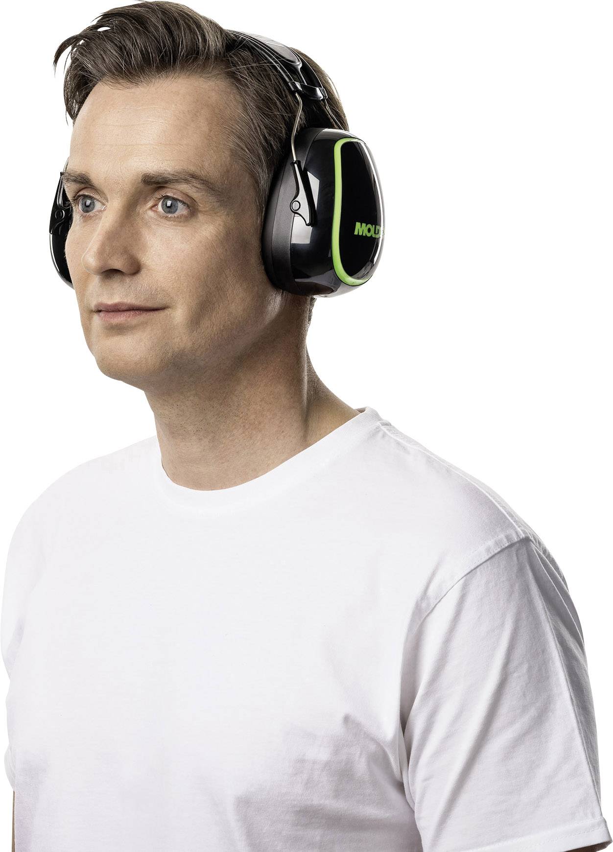 A man wearing a white T-shirt is wearing black and green noise-cancelling headphones.