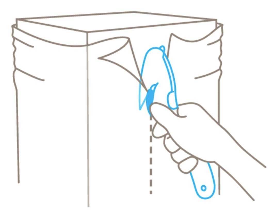 A hand holds a cutting tool, slicing open a package along a dotted line.