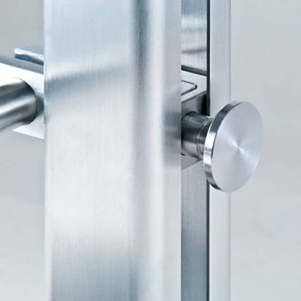 Close-up of a stainless steel door handle, featuring a modern design with a cylindrical grip and smooth finish, mounted on a door.