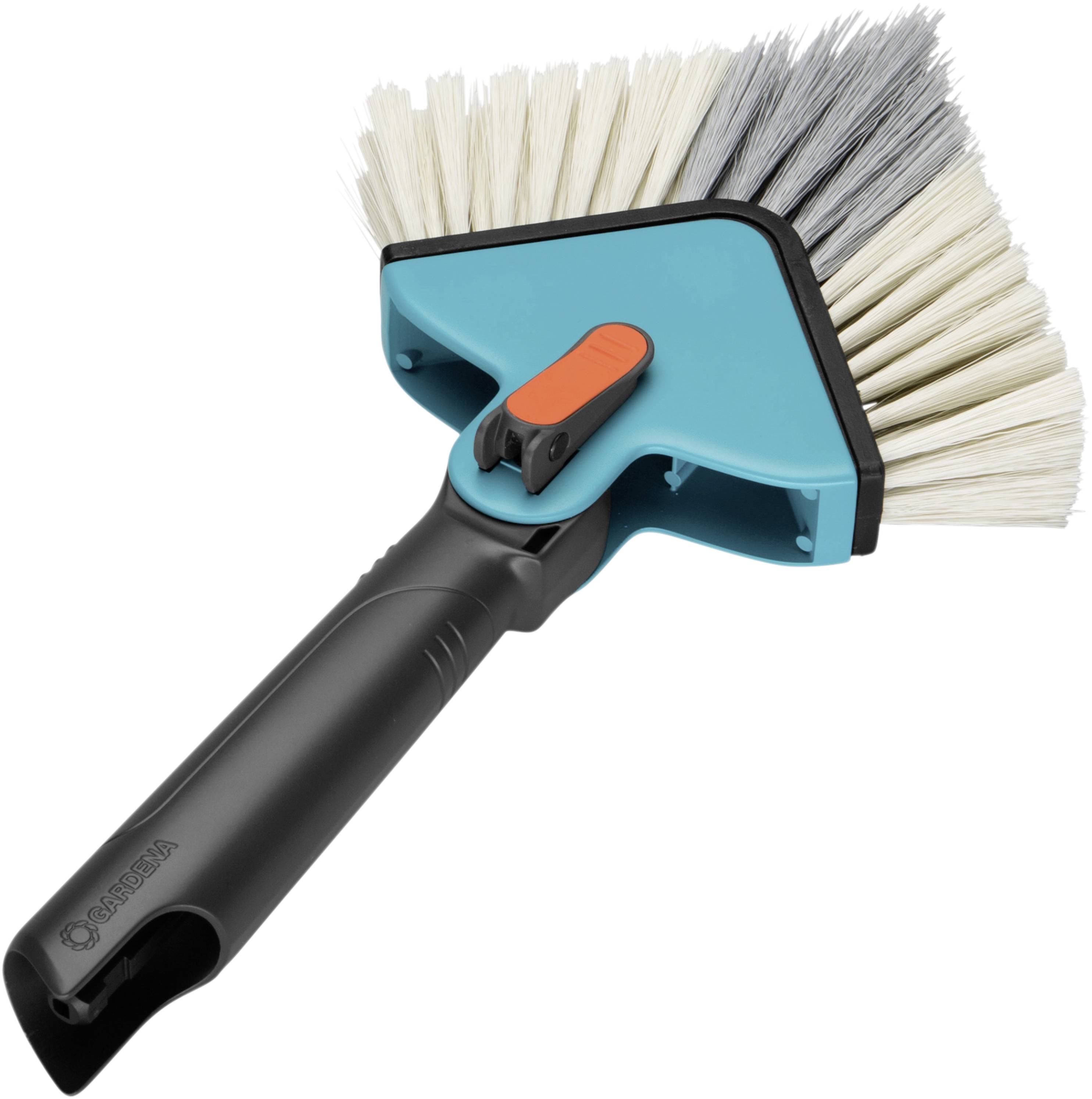A navy blue and black hand brush with bristles in white and grey. An orange button is visible on the brush head.