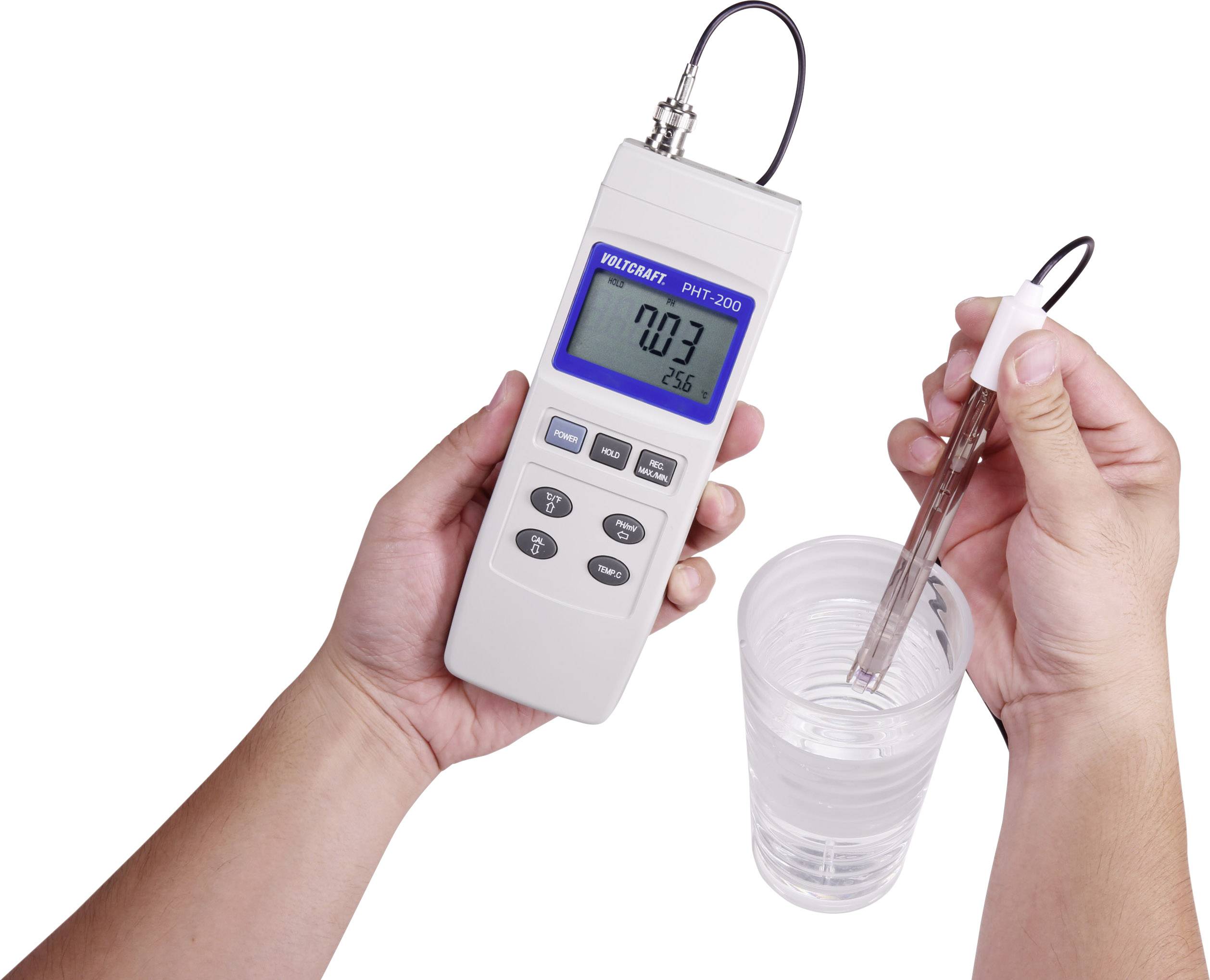 A person is holding a digital measuring device with a probe in a glass of water. The display shows '0.03' and '25.6'.