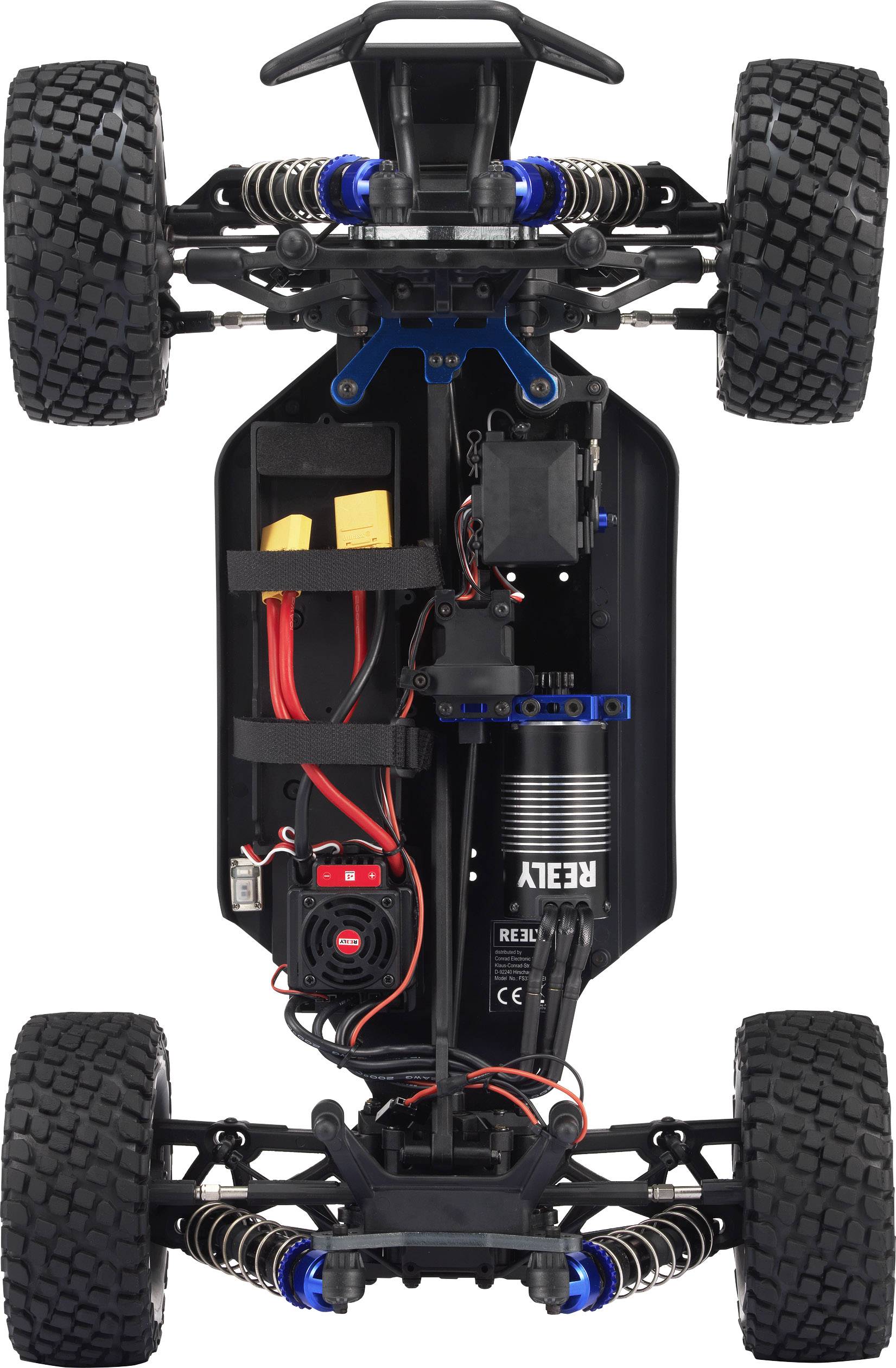 Remote-controlled car viewed from underneath, showing electronics, drivetrain, battery compartments and shock absorbers. Thick tyres protrude from the sides.