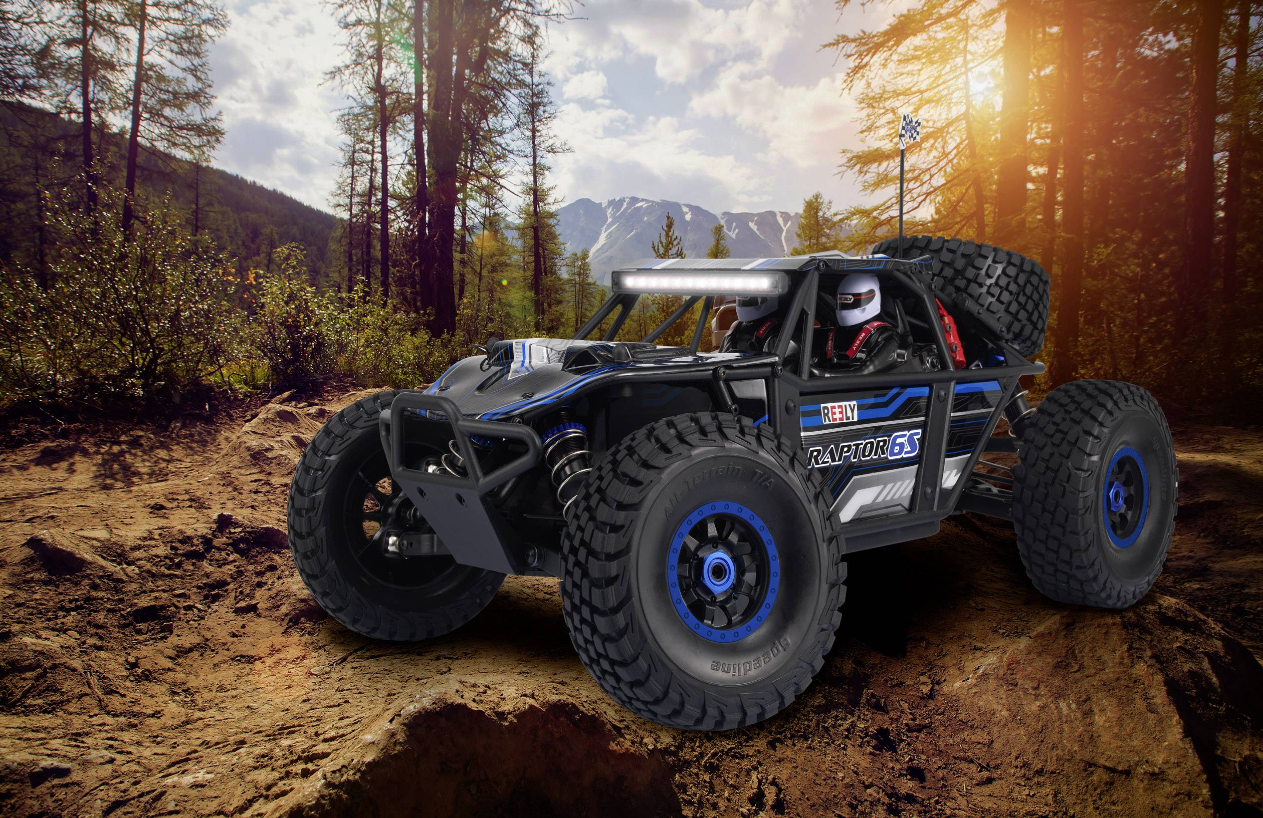 A remote-controlled car in an off-road design on a rocky forest path, with trees and mountains in the background at sunset.