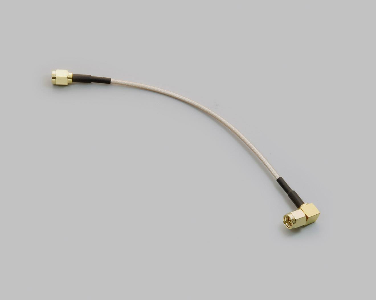 A short cable with a golden plug at each end, lying in a gentle curve. Background is plain grey.