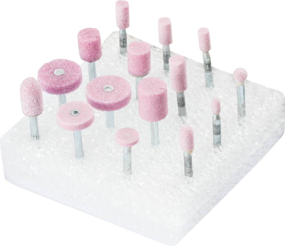 Various pink grinding tools with metal attachments are arranged on a white foam block.