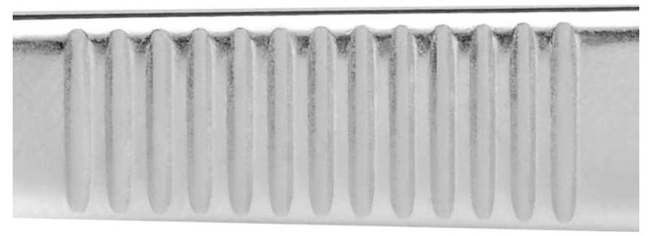 Close-up of a metallic handle with a ribbed pattern.