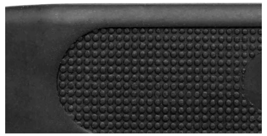 A close-up of a structured, rubberised surface with raised black dots that could enhance grip.