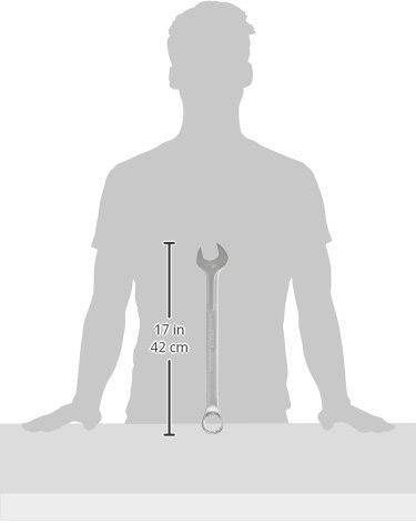 Silhouette of a person standing behind a table. A stillson wrench lies on the table, 42 cm long.
