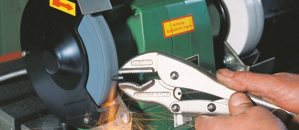 A grinding machine grinds an object while sparks fly. A red warning: 'Caution, sweep grinding stone'.