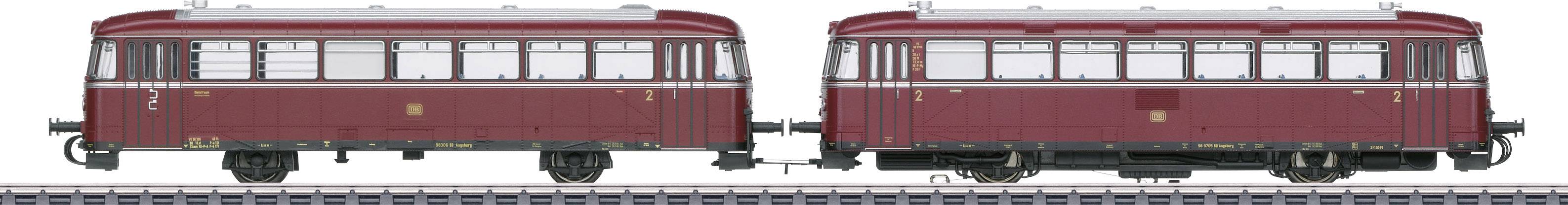 Red historical rail bus in double unit on tracks, side view, windows and roof details visible.