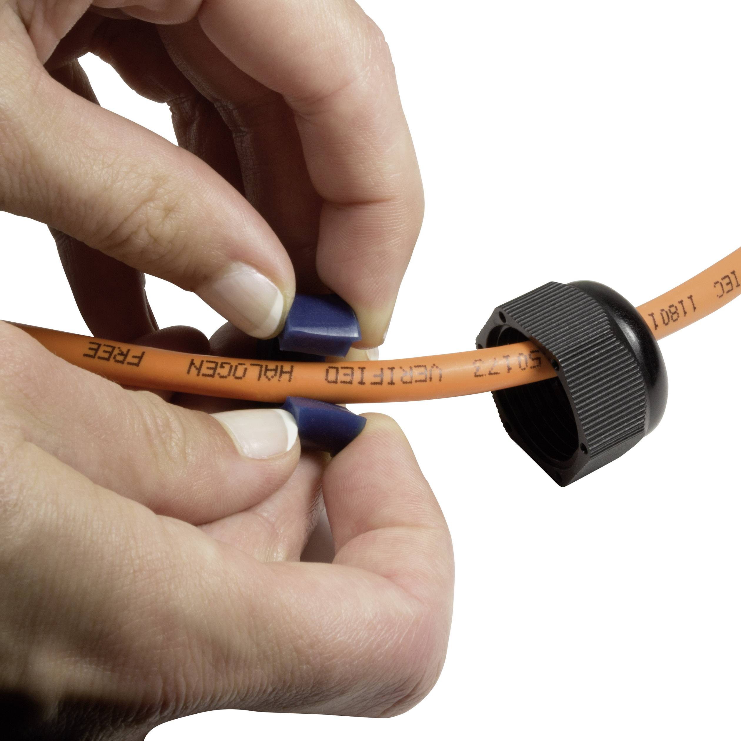A person pulls a orange cable tie tightly, concentrating carefully on securing the cable neatly.