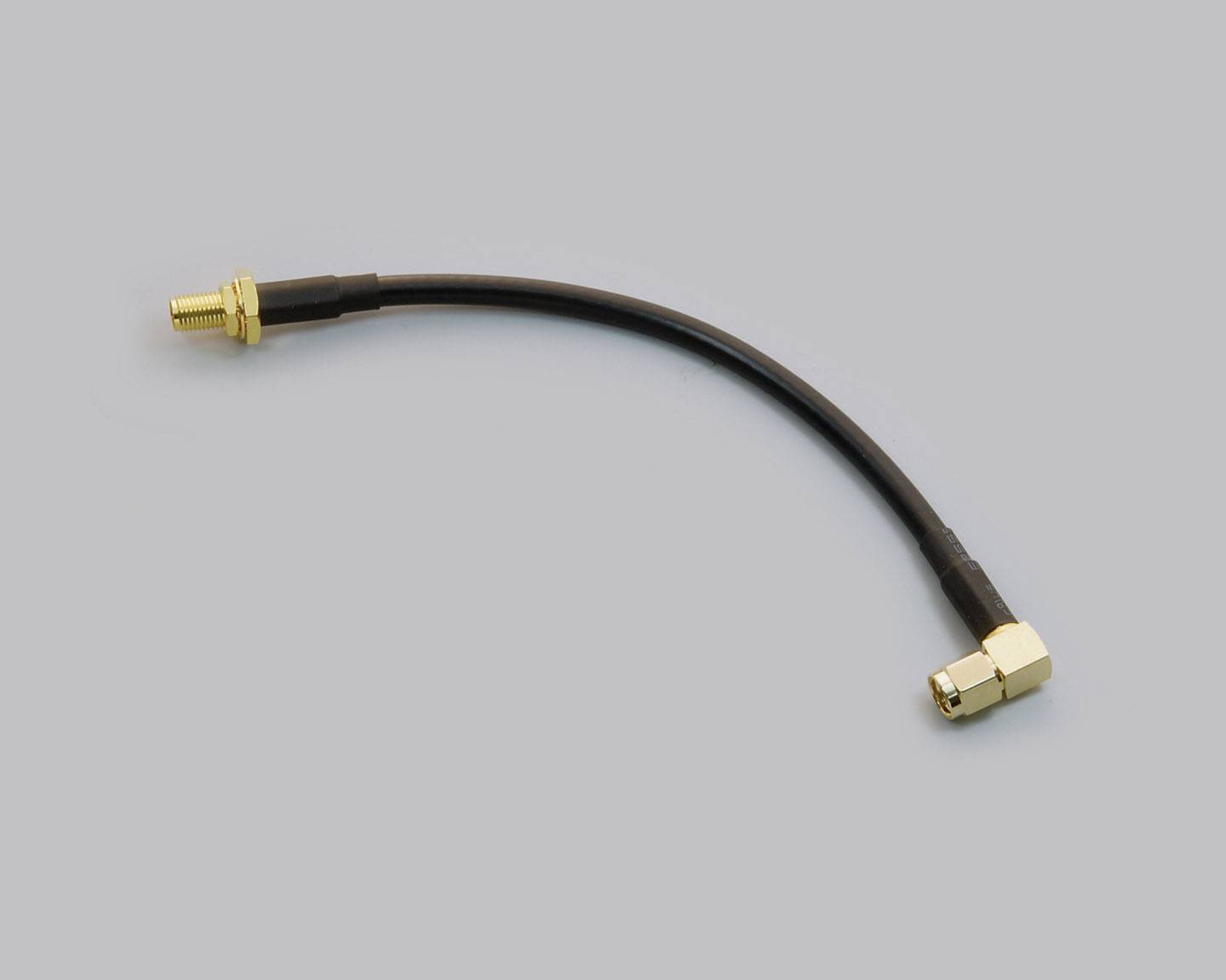 A short cable with gold-plated connectors at both ends, lying on a grey background.<br><br>Note: I've used 