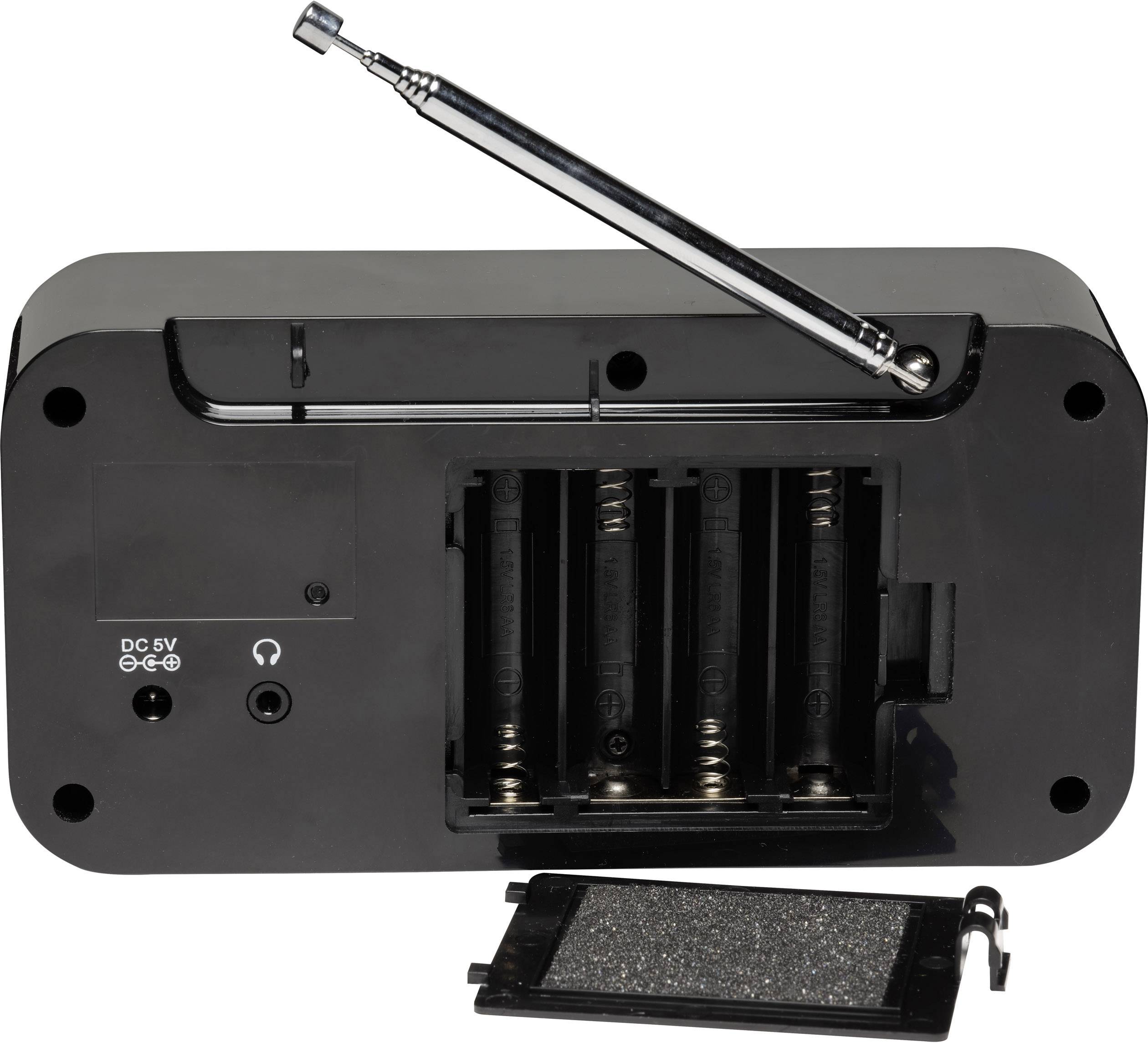 Black electronic device viewed from below, battery compartment open, four empty slots, removed cover beside it, antenna extended at the top.