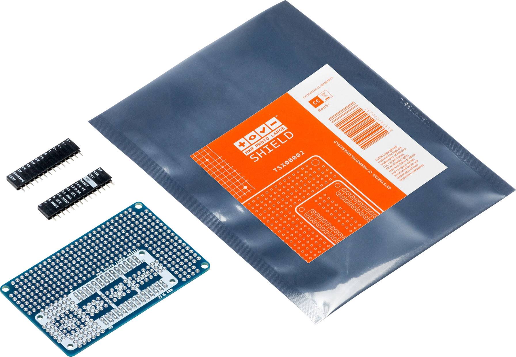 A kit consisting of a microchip, a blue circuit board, and a packaged component with an orange label.