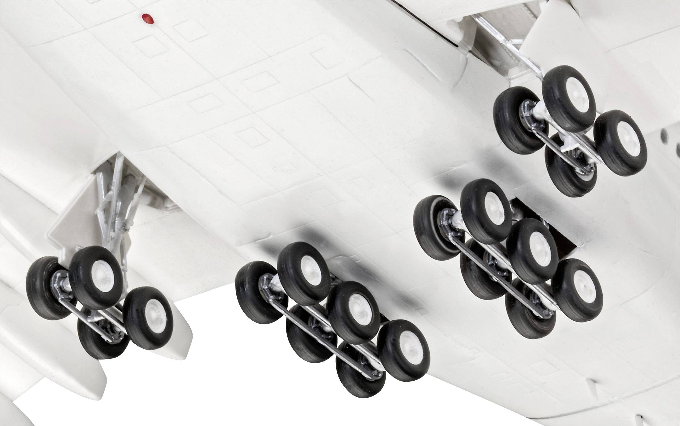 Underside of an aircraft with a detailed view of the landing gear, showing multiple tyres, supporting take-off and landing.