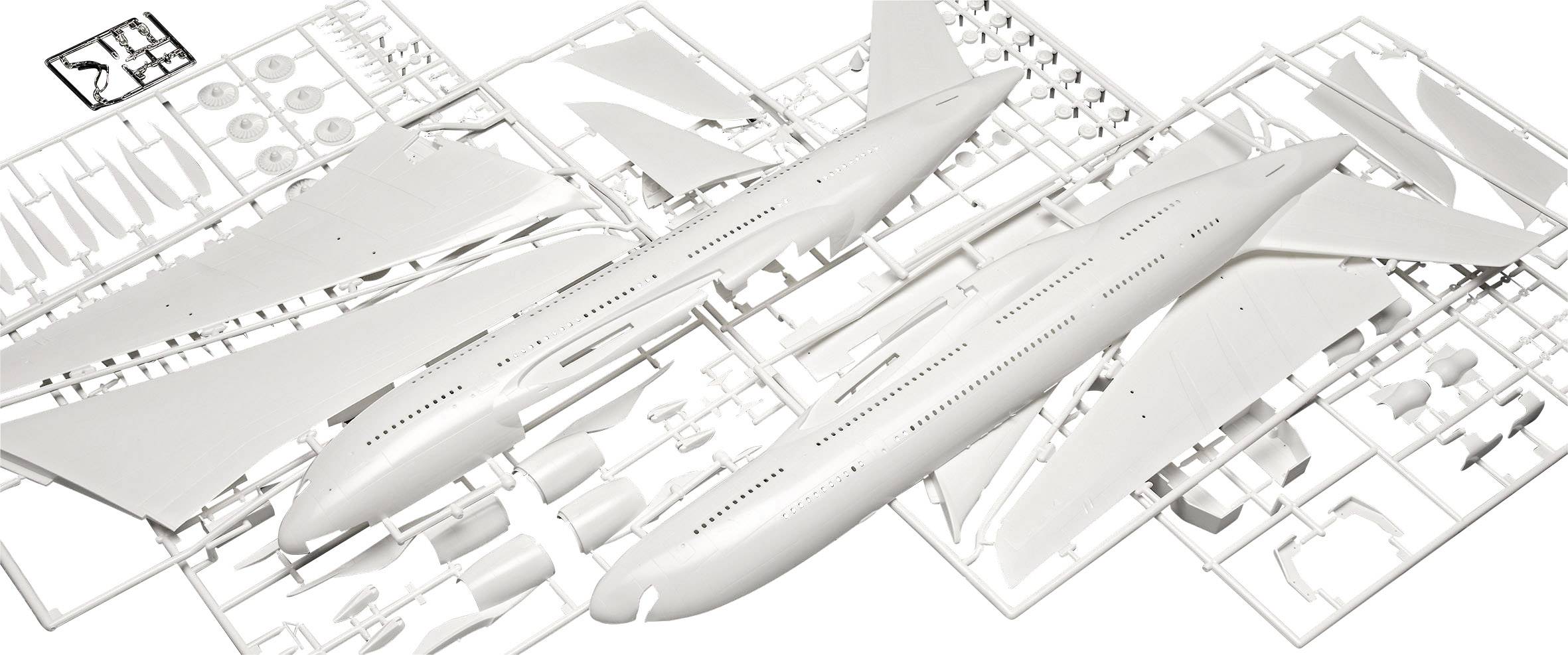 A plastic model kit of an aircraft shows individual parts of a passenger jet ready for assembly. Wings, fuselage and wheels are visible.