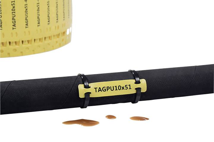 A black cable, secured with a yellow tag 'TAGPU10x51'. Liquid droplets are lying on the surface beside it.