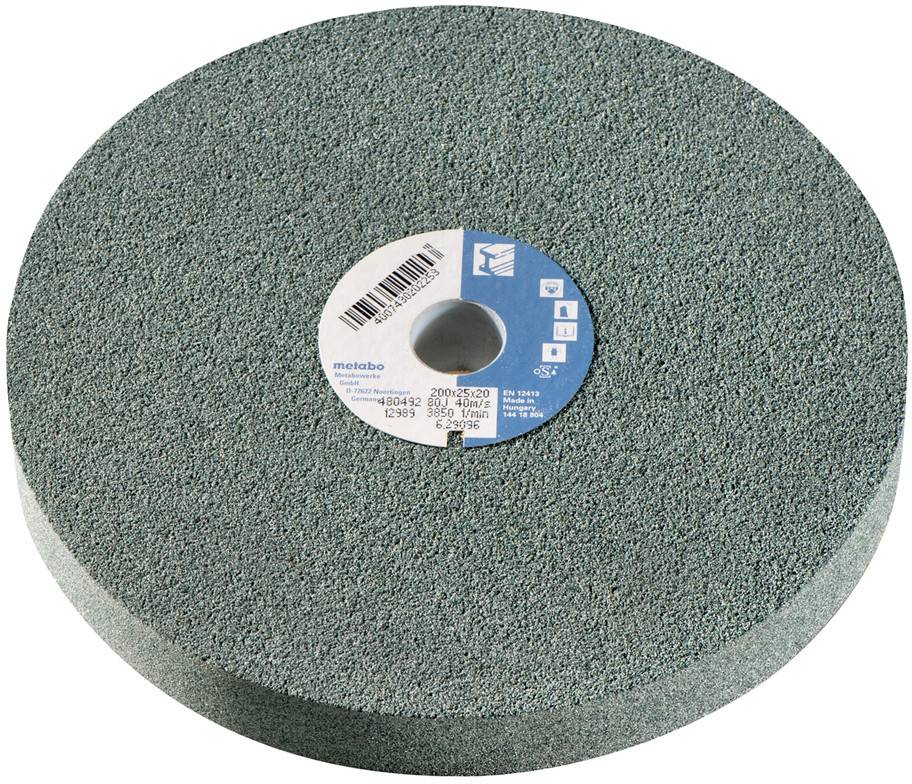 A round green grinding stone with a central label, lying on a white surface.