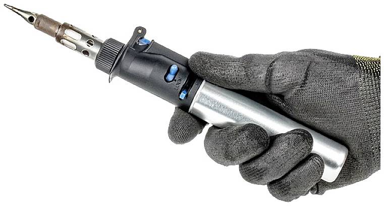 A hand wearing a black glove holds a soldering iron.